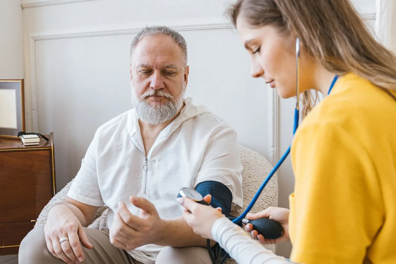 Une soignante prend la tension d’un patient