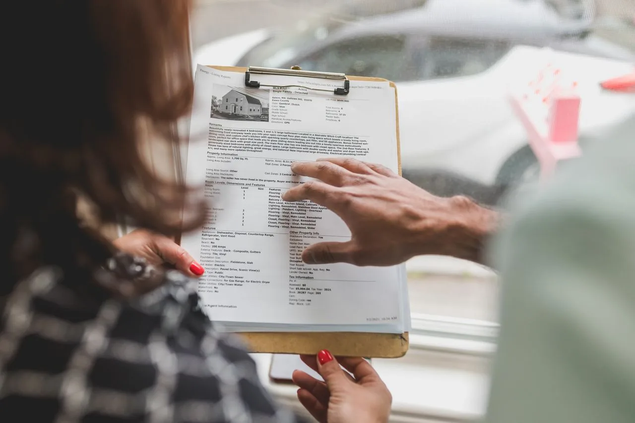 Un conseiller remet un dossier à ses clients