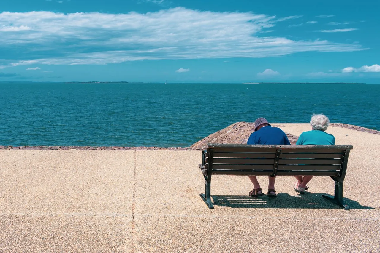 Un couple de retraités assis face à la mer