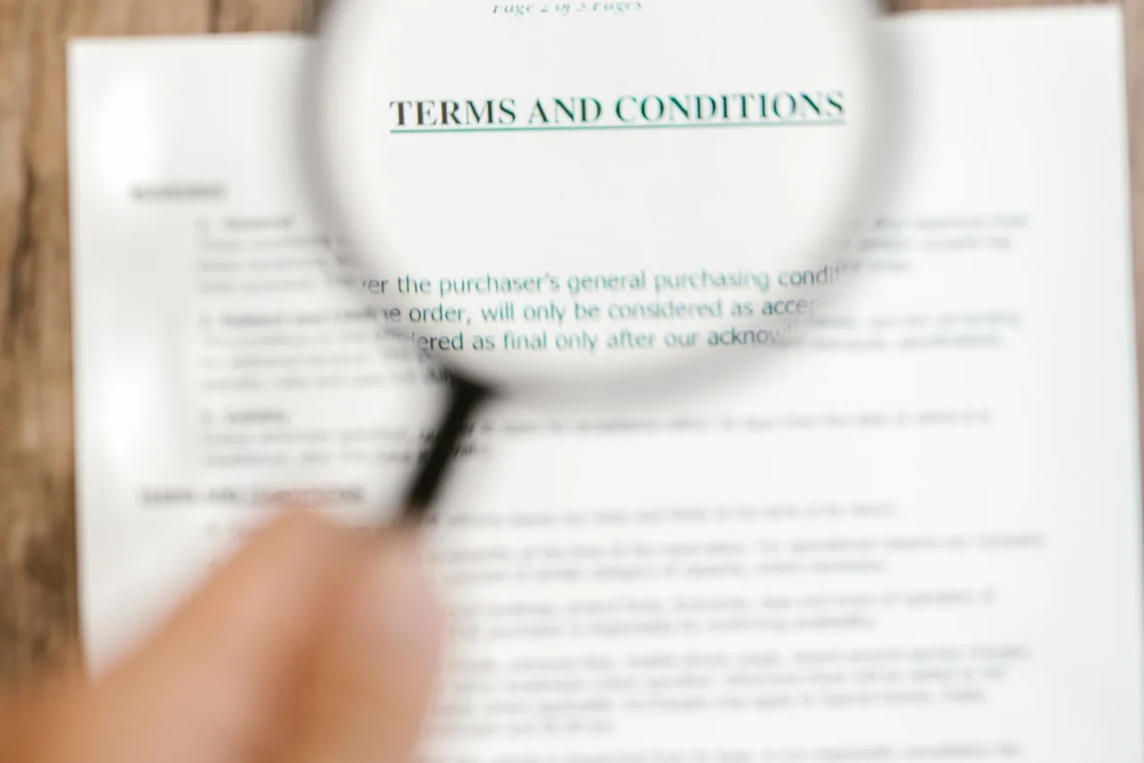 Une personne relit attentivement les conditions d’un contrat